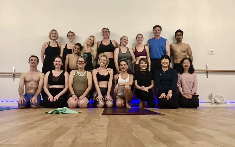 The Urban Fit Yoga class group photo — teachers and students together in the studio after a session